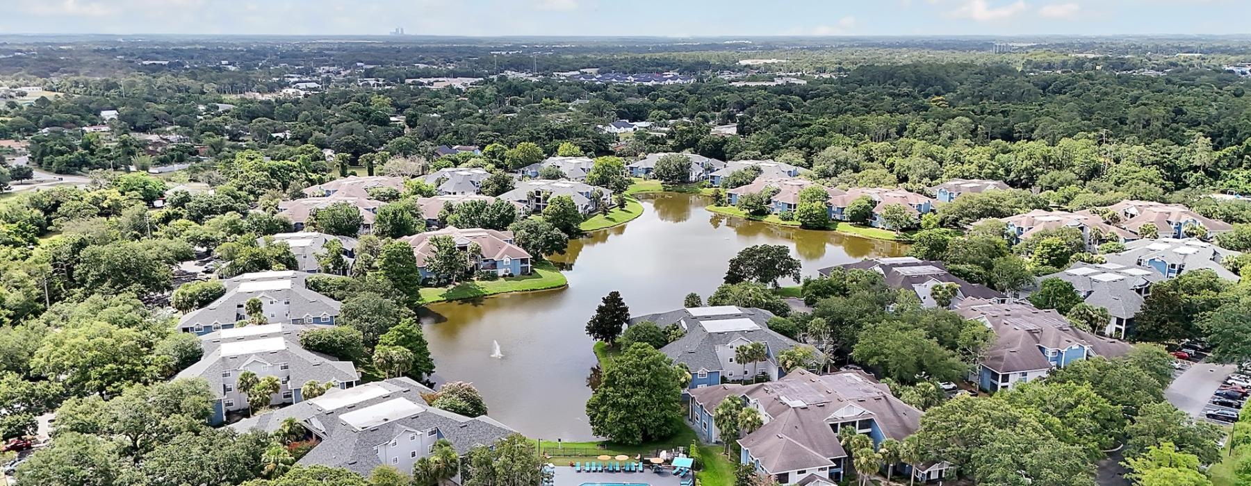 an aerial view of an apartment and a body of water