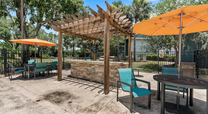 Grilling station near tables with umbrellas